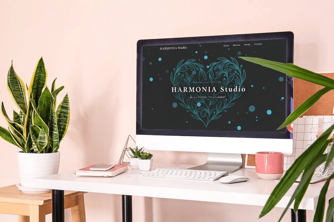 HARMONIA Studioのウェブサイトが表示されたデスクの写真